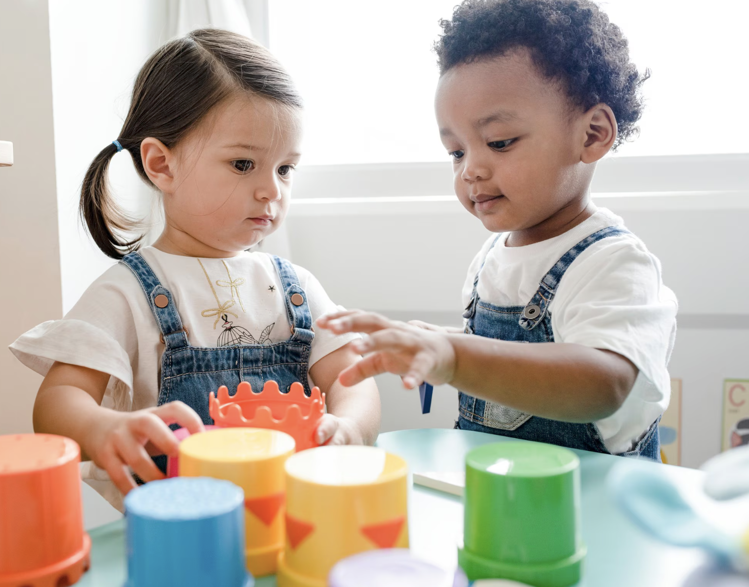 Deux enfants en service de garde jouent avec des jouets d'empilage colorés